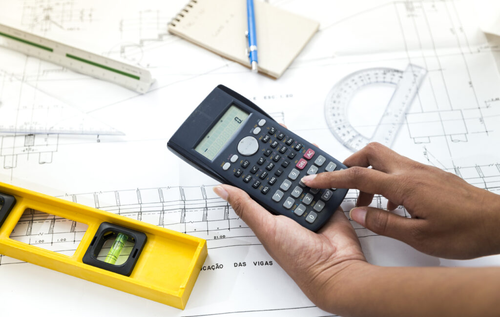 woman using calculator near plan equipments